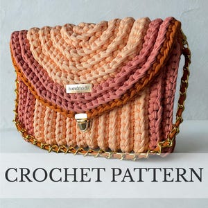 Op de afbeelding: Een handgemaakte gehaakte tas in tinten perzik, roze en oranje met een gouden kettingriem en sluiting. De tas heeft een gevlochten ontwerp en een klein metalen label met de tekst "handmade". De tekst "CROCHET PATTERN" staat eronder.