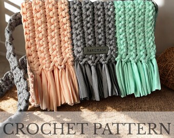 May include: A handmade crochet bag with a braided strap. The bag is divided into three vertical sections of peach, gray, and mint green. Each section has a fringe at the bottom. The word "handmade" is on a small metal tag.