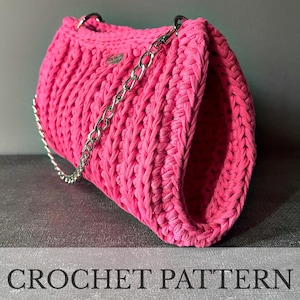 May include: A vibrant pink crocheted handbag with a silver chain strap. The bag features a chunky, textured weave and a rectangular form. The words "CROCHET PATTERN" are displayed at the bottom of the image.