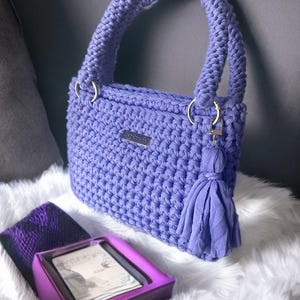 This crochet pattern helps you craft a beautiful crochet tote with a modern crochet design. Its sleek structure and decorative tassel make it the perfect pattern for beginners looking to create a durable crochet bag with professional results.
