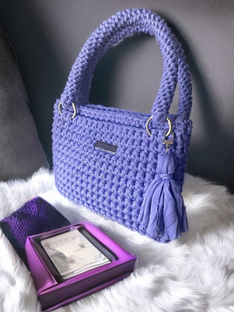This crochet pattern helps you craft a beautiful crochet tote with a modern crochet design. Its sleek structure and decorative tassel make it the perfect pattern for beginners looking to create a durable crochet bag with professional results.