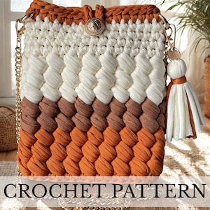 Può includere: Borsa all'uncinetto fatta a mano con tracolla a catena dorata. La borsa presenta un design a blocchi di colore in bianco, marrone e arancione. Un bottone e un nappa dorati aggiungono dettagli decorativi. Il testo "CROCHET PATTERN" è visibile.