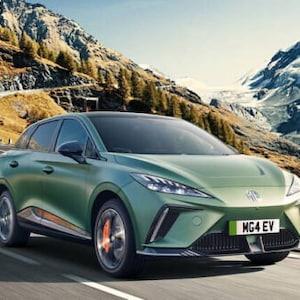 Puede incluir: Un coche eléctrico MG4 EV verde conduciendo por una carretera sinuosa a través de un paso de montaña. El coche tiene una matrícula que dice "MG4 EV".