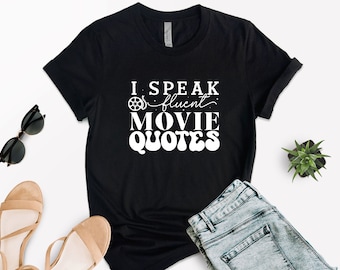May include: Black t-shirt with white text that reads "I speak fluent movie quotes" with a film reel icon.