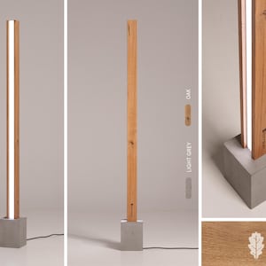 Pu&ograve; includere: Una lampada da terra moderna con una base in legno rettangolare lunga e una striscia di luce bianca che corre al centro. La base &egrave; in cemento e ha una forma quadrata. La lampada &egrave; disponibile in due finiture in legno: rovere e grigio chiaro.