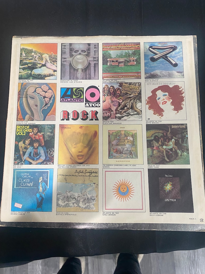 May include: A collage of album covers from the 450 Atlantic Atco Rock series. The covers feature various artists, including The Bee Gees, The Rolling Stones, Genesis, and King Crimson. The album covers are a mix of colors and styles, with some featuring portraits of the artists and others featuring abstract designs.