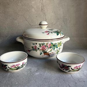 Peut inclure: Un plat de service en c&eacute;ramique cr&egrave;me avec un couvercle et deux bols assortis. L'ensemble pr&eacute;sente un motif floral avec des fleurs roses et vertes et une bordure marron. Le plat de service a deux poign&eacute;es et un bouton rond sur le couvercle.