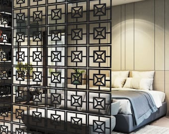 May include: Black room divider with a geometric pattern. The divider is made of metal and has a square shape. It is standing in front of a bed with white bedding and pillows.