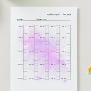 May include: A white sheet of paper with a grid-like chart labeled "ROW/REPEAT TRACKER." The chart has columns for rows 1-100, with a watercolor-style purple and pink splash in the center. The top of the page has the words "DESIGNER" and "PROJECT TITLE."