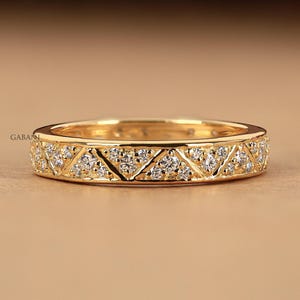 Könnte beinhalten: Eine weiße Keramik-Tasse mit schwarzem Henkel und dem Text "But First, Coffee" in schwarzer, handschriftlicher Schrift. Die Tasse steht auf einer weißen Oberfläche.