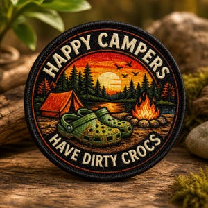 May include: Round patch with the text "HAPPY CAMPERS HAVE DIRTY CROCS." The patch features a camping scene with a tent, campfire, and green Crocs. The background shows a sunset over a lake and trees.