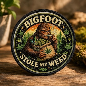May include: Round patch featuring Bigfoot smoking a joint, with a bag of marijuana. The text "BIGFOOT STOLE MY WEED" is in a circular design around the image. The background includes a forest and sunset.