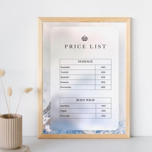 Könnte beinhalten: Eine gerahmte Preisliste für ein Spa oder einen Salon mit weißem Hintergrund und floralem Design. Die Liste enthält Preise für Massage- und Körperwickelbehandlungen. Die Preise sind in Euro angegeben.