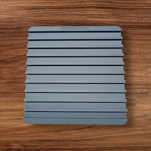 Puede incluir: Un porta lápices y bolígrafos de plástico gris con 10 ranuras. El porta lápices tiene las palabras "PEN/PENCIL" impresas en la parte superior.