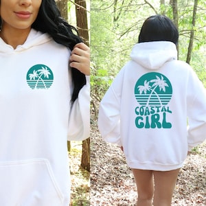May include: White hooded sweatshirt with a teal palm tree graphic on the front and "COASTAL GIRL" text with a palm tree graphic on the back.
