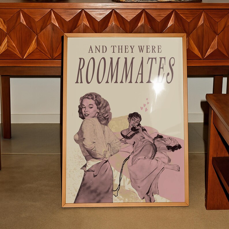 A framed print with two ladies in a romantic pose, with the text 'and they were roommates'.