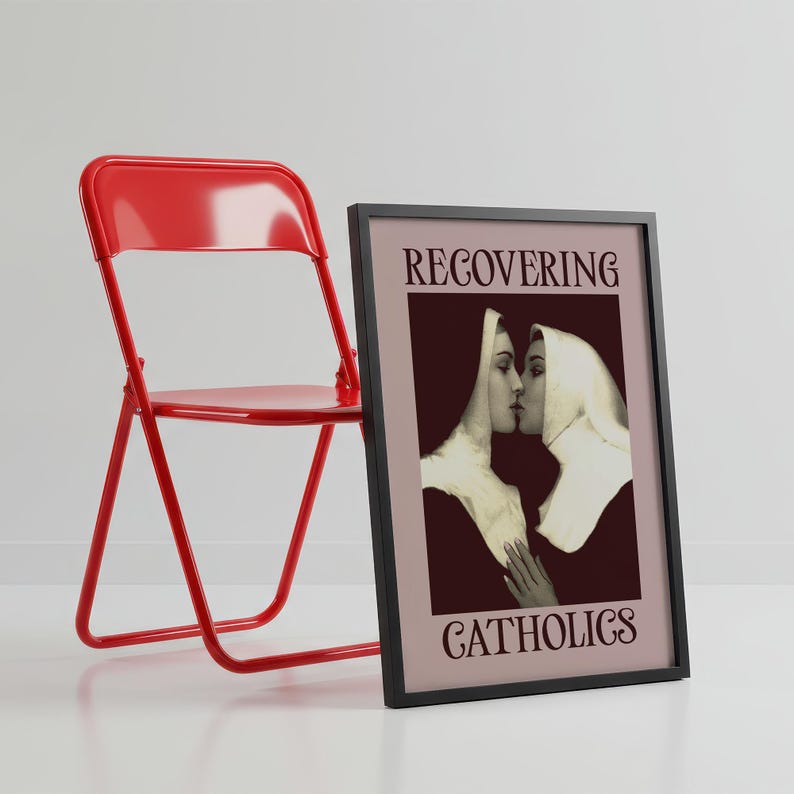 A framed poster featuring two kissing nuns, paired with the text "RECOVERING CATHOLICS."