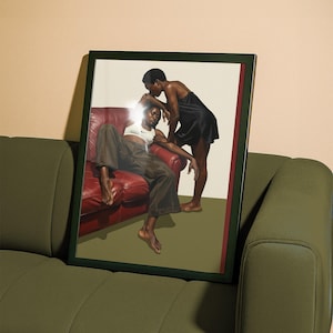 A framed poster with a black, lesbian couple kissing.