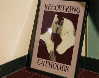 May include: Framed artwork featuring two nuns kissing, with the text "RECOVERING CATHOLICS" in a serif font. The image has a sepia tone, with the nuns in black habits and white veils. The frame is black, and the artwork is leaning against a wall.