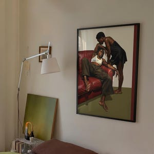 A framed poster with a black, lesbian couple kissing.
