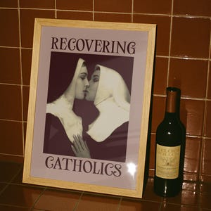 A framed poster featuring two kissing nuns, paired with the text "RECOVERING CATHOLICS."