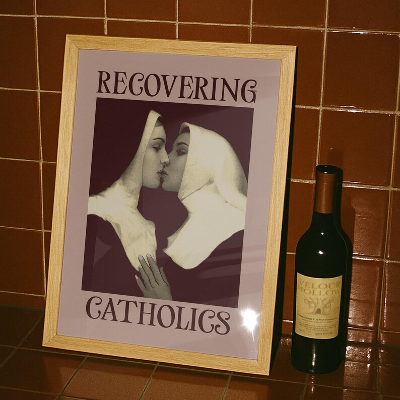 A framed poster featuring two kissing nuns, paired with the text "RECOVERING CATHOLICS."