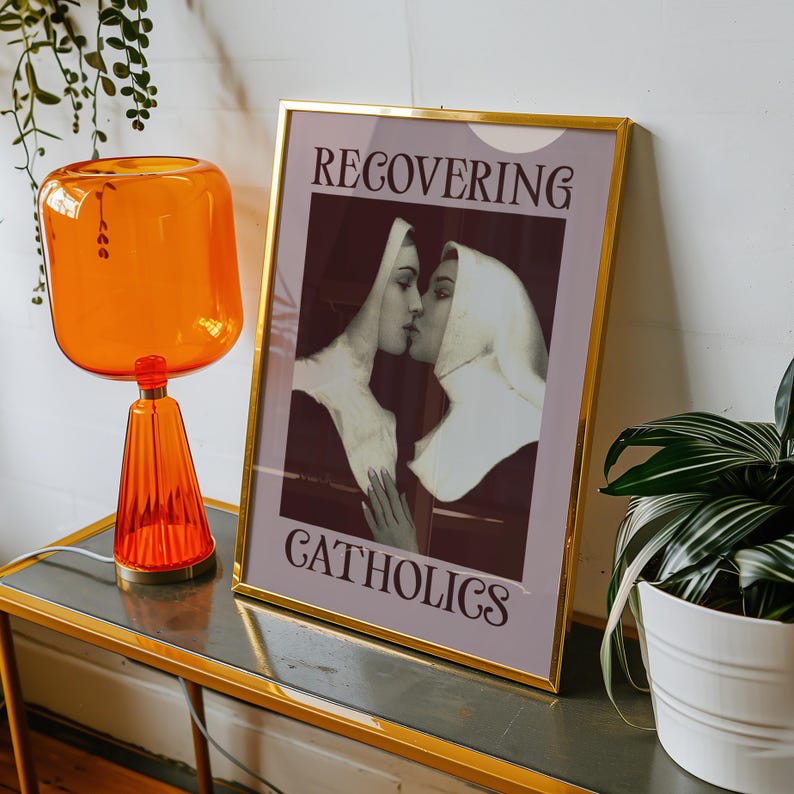 A framed poster featuring two kissing nuns, paired with the text "RECOVERING CATHOLICS."