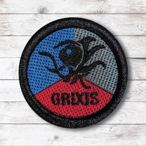 May include: Circular embroidered patch with a black border. The patch is split into blue, grey, and red sections. A black graphic and the word "GRIXIS" are displayed on the patch.