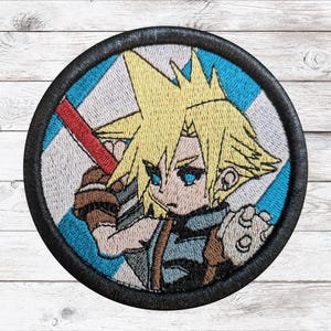 May include: Embroidered patch depicting a cartoon character with spiky blonde hair, blue eyes, and a determined expression. The character holds a red object. The patch has a black border and a blue and white background.