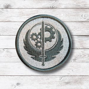 Peut inclure: Une tasse en céramique blanche avec une anse noire et le texte "But First, Coffee" en noir, en gras. La tasse est posée sur une surface blanche.