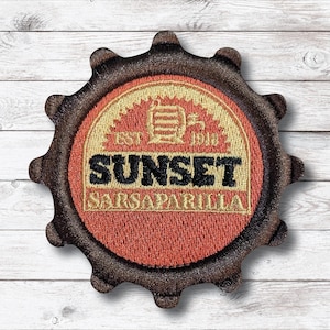 Puede incluir: Parche bordado en forma de engranaje con el texto "SUNSET SARSAPARILLA" en negro y dorado. El parche tiene un centro rojo y dorado con un gráfico de barril y el texto "EST. 1912". El borde es marrón.