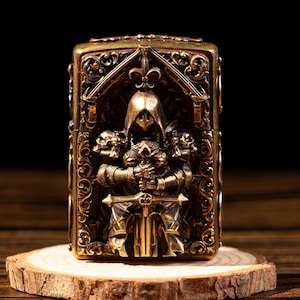 May include: A detailed brass lighter featuring a knight in full armor holding a sword, set against an arched backdrop. The lighter has ornate scrollwork and skull details, resting on a wooden slice.
