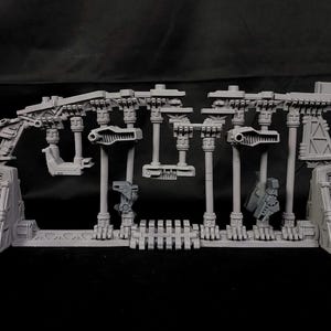 May include: A set of grey plastic model pieces for building a futuristic structure. The pieces are detailed with intricate designs and include various shapes and sizes.