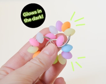 May include: A colorful glow-in-the-dark fidget toy with a metal ring and pastel-colored beads. Glows in the dark!