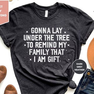 Gonna Lay Under The Tree To Remind My Family That I Am A Gift Shirt, Funny Christmas Gift T-Shirt, New Year Shirt, Family Xmas Party Tee