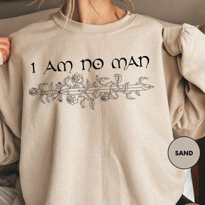 a woman wearing a sweatshirt that says i am no man