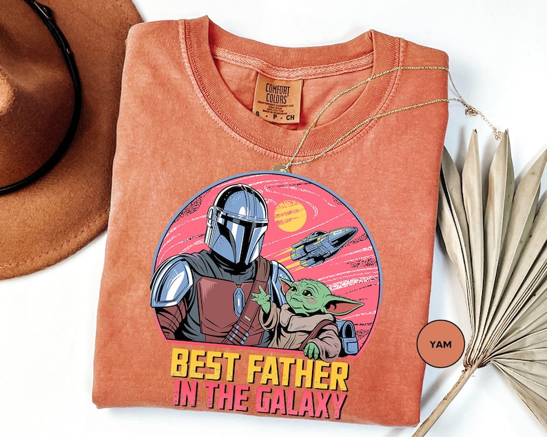 a t - shirt with a picture of a man and baby yoda on it