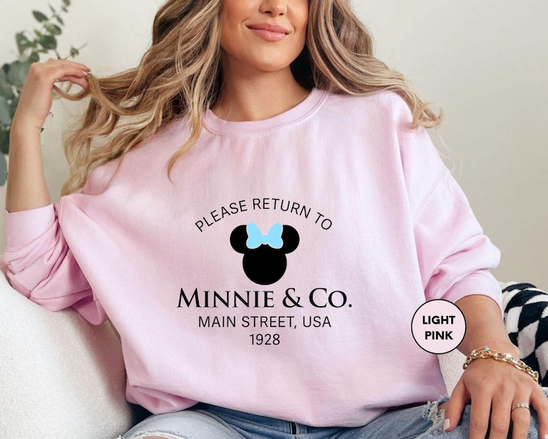 a woman sitting on a couch wearing a pink shirt