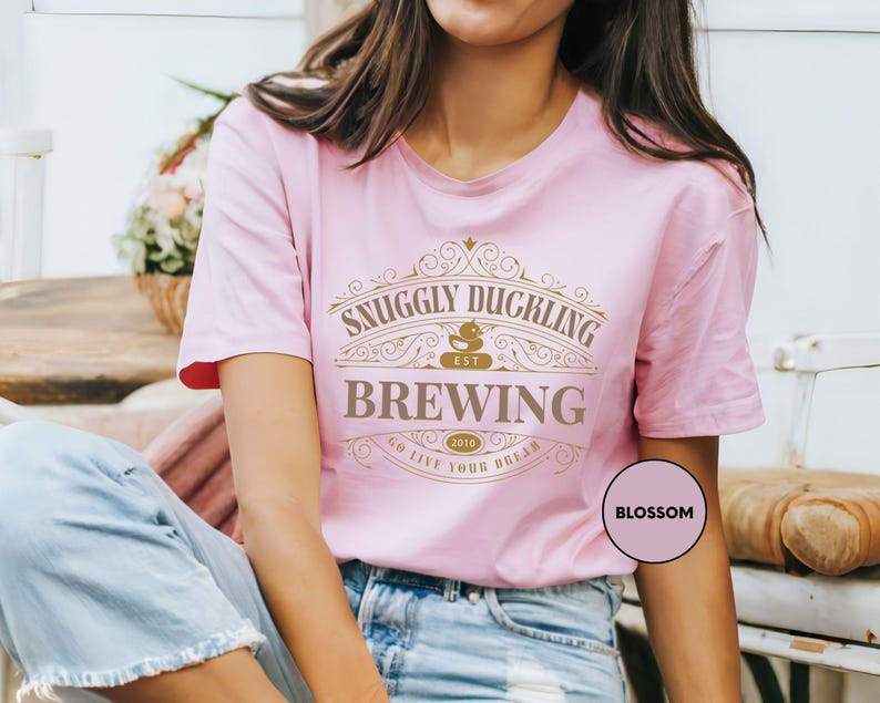 a woman wearing a pink t - shirt with a saying on it