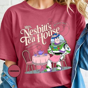 a woman wearing a t - shirt with a cartoon character on it