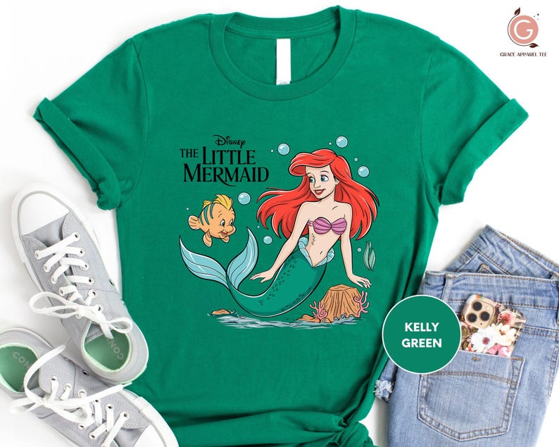 a green shirt with a little mermaid on it