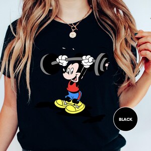 a woman wearing a mickey mouse t - shirt