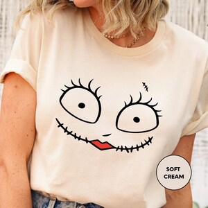 a woman wearing a t - shirt with a face drawn on it