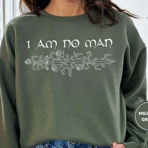 a woman wearing a sweatshirt that says i am no man