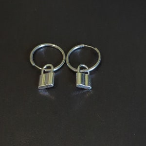 May include: A pair of silver hoop earrings with small padlock charms hanging from them.