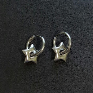 May include: A pair of silver hoop earrings with a star charm attached to each hoop.