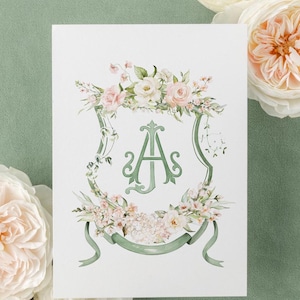 May include: A white card with a green and white floral design and a green monogram "A" in a shield shape.
