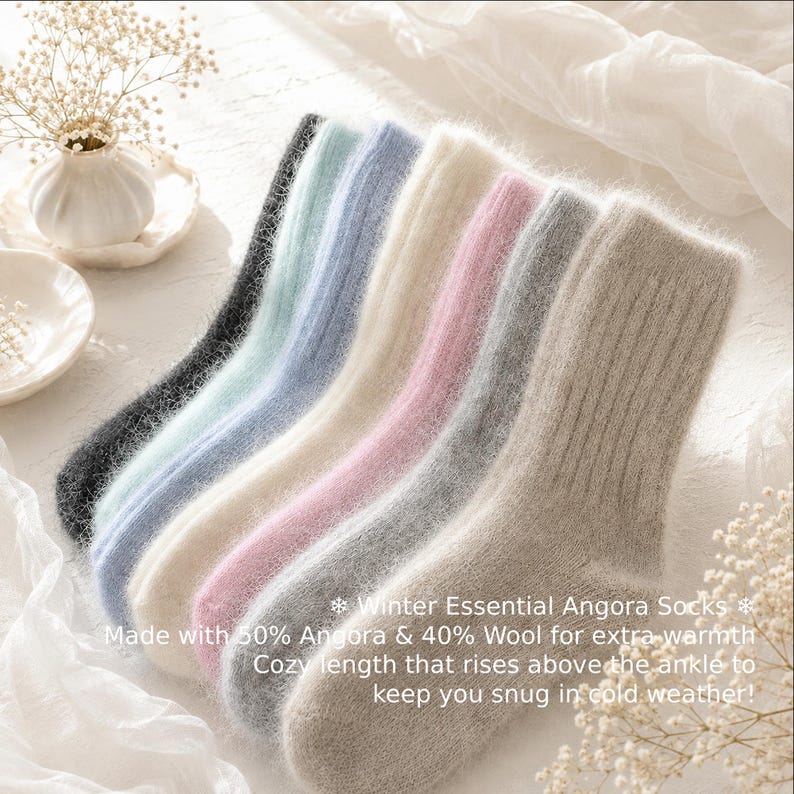 May include: A set of six fuzzy, ribbed socks in black, light blue, blue, cream, pink, and beige. The text on the image reads: Winter Essential Angora Socks, Made with 50% Angora & 40% Wool for extra warmth, Cozy length that rises above the ankle to keep you snug in cold weather!