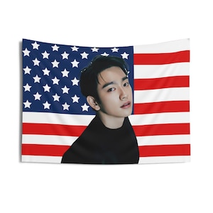 Könnte beinhalten: Eine schwarz-weiße amerikanische Flagge mit dem Gesicht eines Mannes in der Mitte. Der Mann trägt ein schwarzes T-Shirt mit Stehkragen.