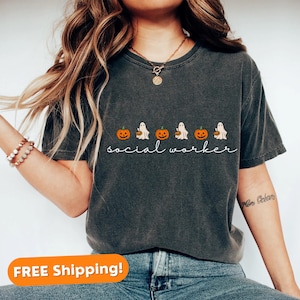 May include: A dark gray t-shirt with a Halloween-themed design featuring ghosts carrying pumpkins and the text "social worker".